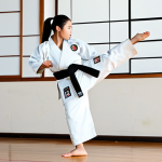 A professional female Taekwondo practitioner in a clean, white dobok, executing a powerful high roundhouse kick (Dolyo Chagi) with precision and explosive force. She is in a well-lit, spacious dojo with a polished wooden floor. Her expression shows intense focus and determination. The image captures the dynamic movement at the peak of the kick. Fully clothed, modest clothing, appropriate attire, professional dress, safe for work, appropriate content, professional, perfect anatomy, correct proportions, natural pose, well-formed hands, proper finger count, natural body proportions, professional photography, high quality.